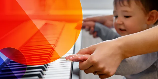 Ein Kind versucht auf einem Klavier zu spielen.