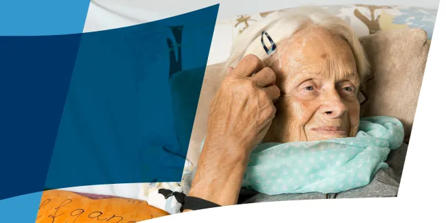 Eine lächelnde ältere Dame im Hospizbett