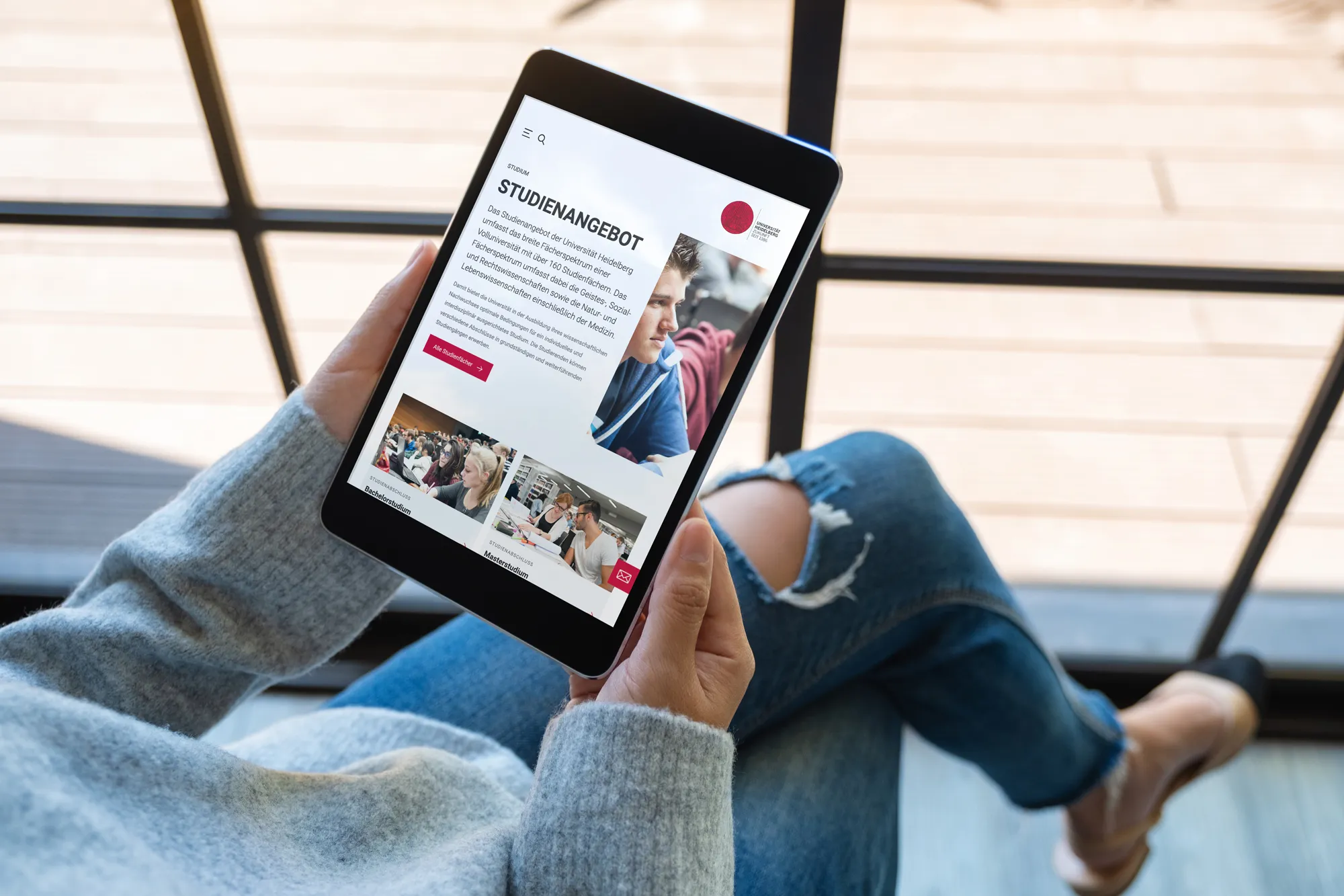 Eine Frau schaut sich die Website der Uni Heidelberg auf einem Tablet an.