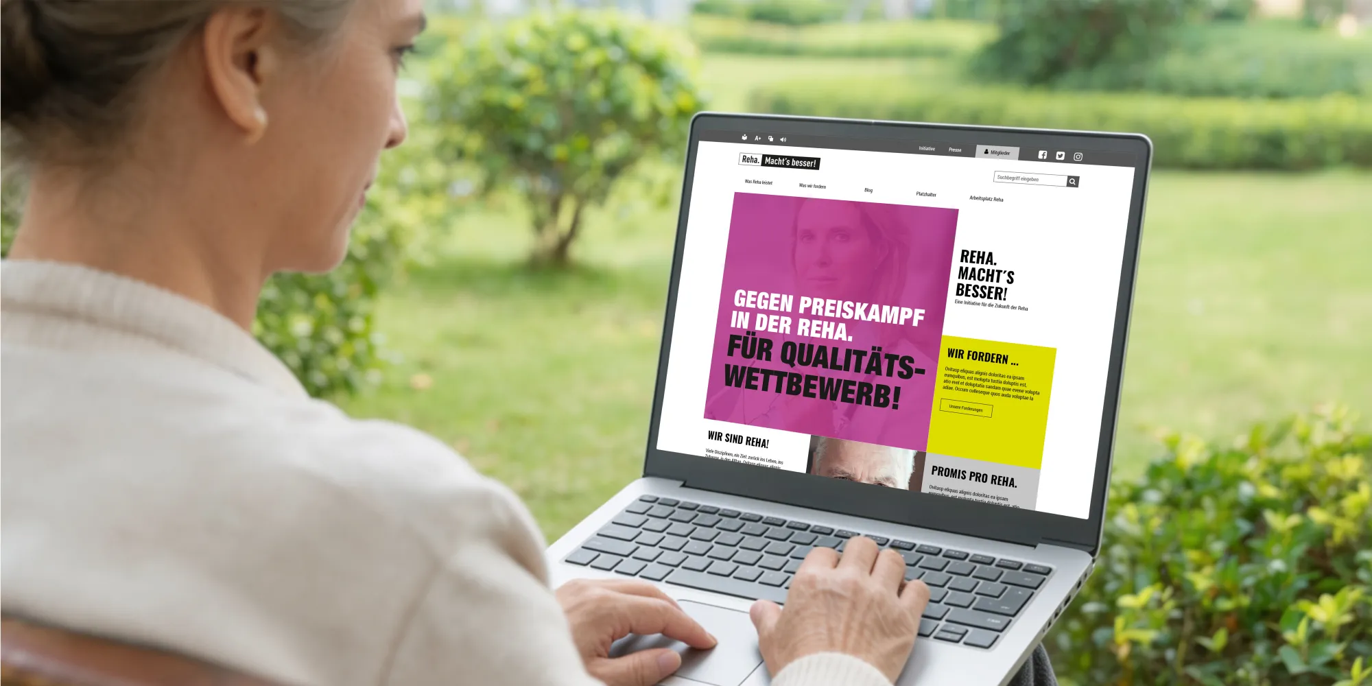 Eine Frau schaut sich in einem Krankenhausgarten auf einer Bank, die Website der Kampagne an.