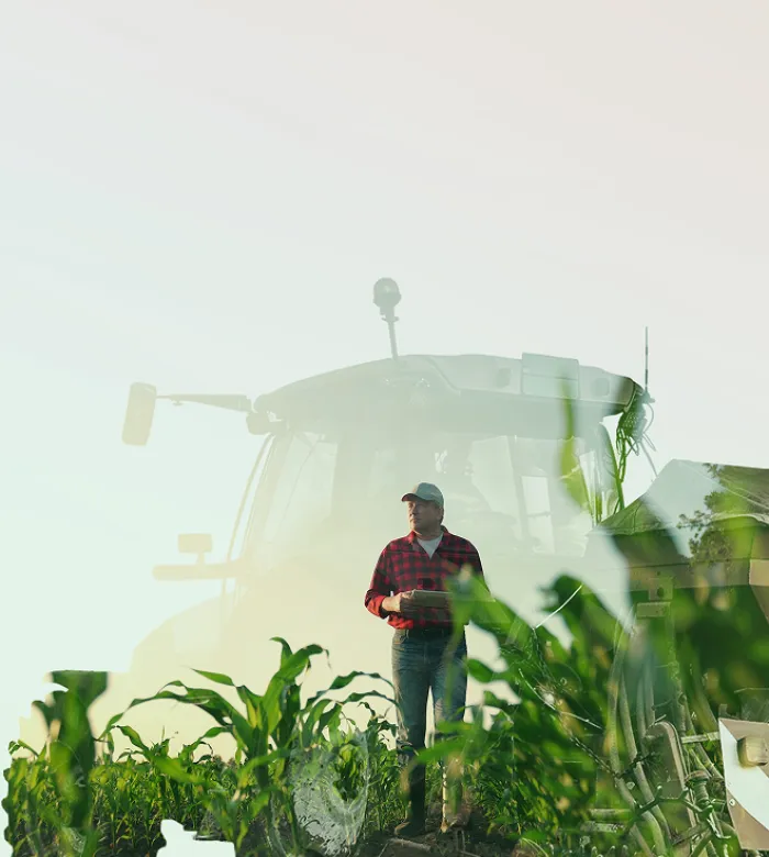 Eine Doppelbelichtigung eines Landwirts und eines Traktors auf einem Feld