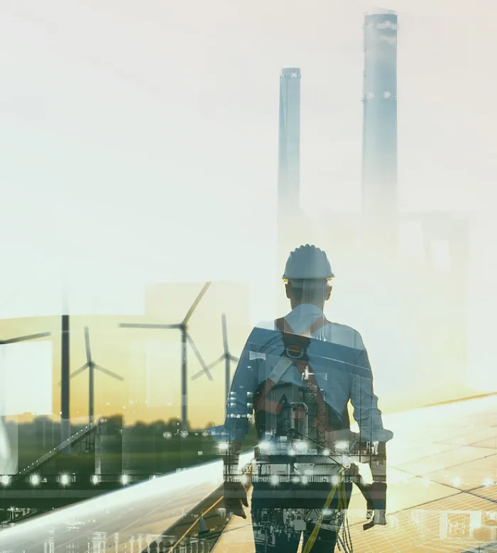 Ein Doppelbelichtigungsbild eines Arbeiters mit Helm und Windräder