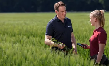 Ein BASF Berater unterhält sich mit einer Frau auf einem Feld.