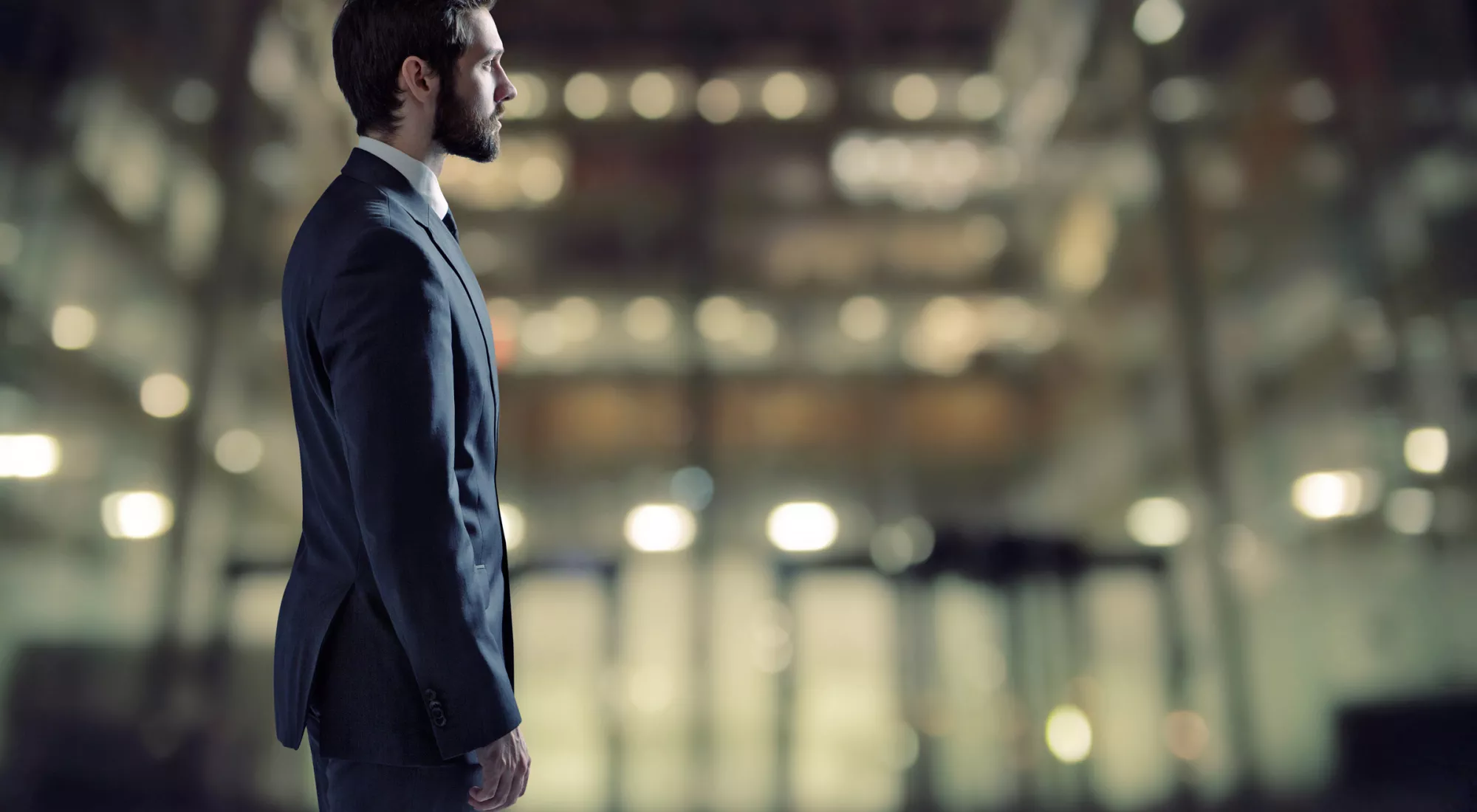 Business man standing in front of building at night