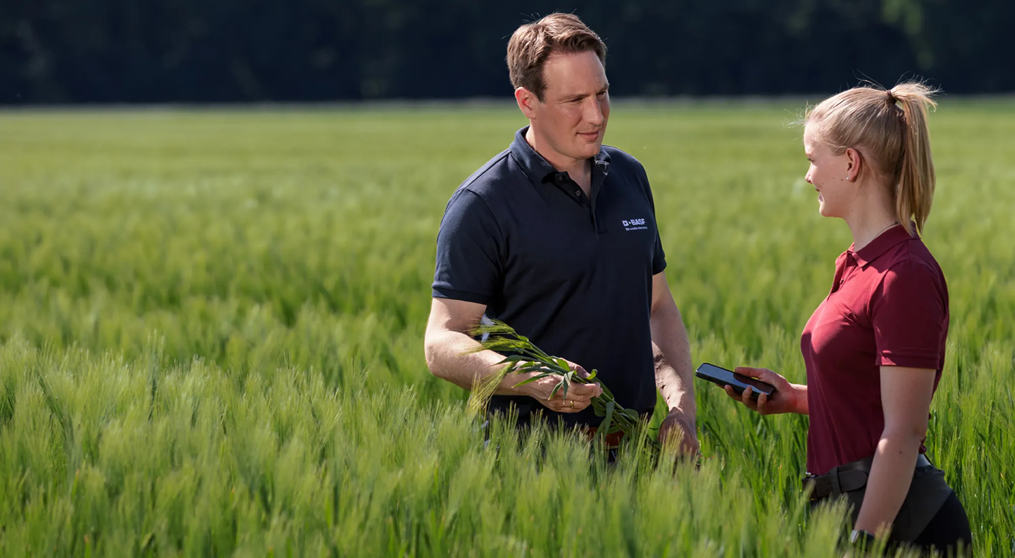 Ein BASF Berater unterhält sich mit einer Frau auf einem Feld.